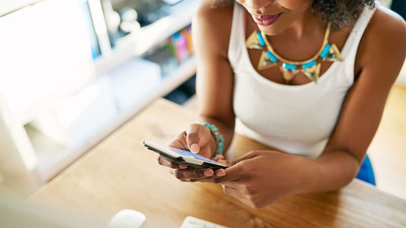 fashionable young woman texting at her desk