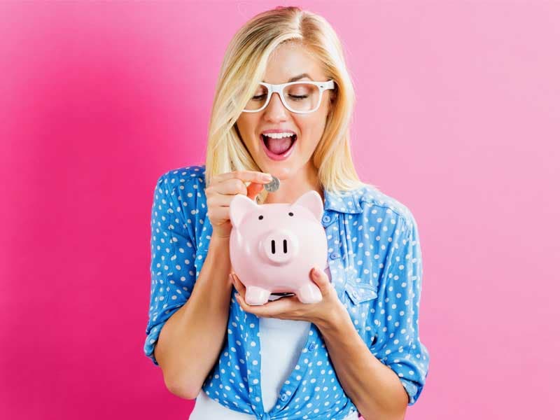 7975women putting change in piggy bank