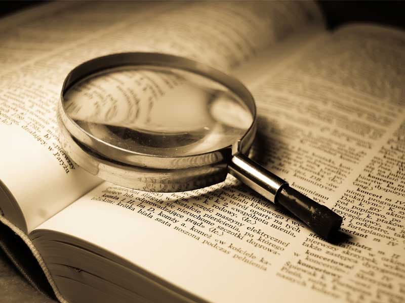 Magnifying glass on dictionary