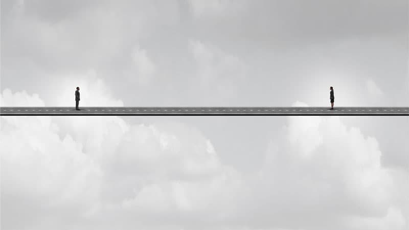 far away concept with two people standing at a distance on a bridge