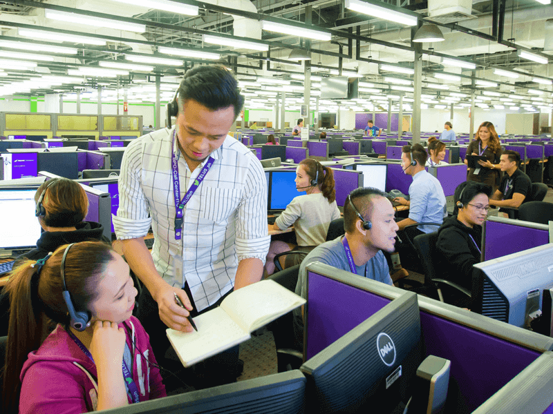 Agent on contact center floor coaching another agent