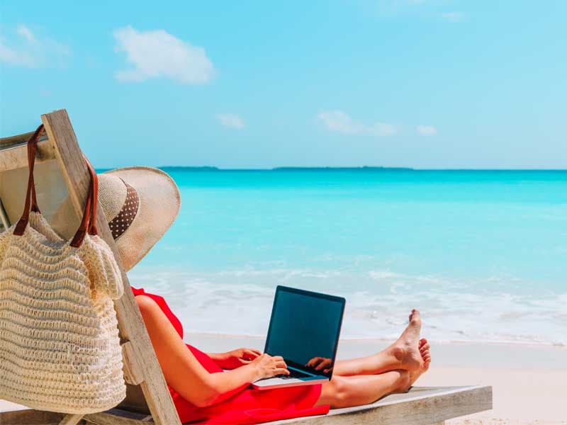 woman sitting on beach with laptop