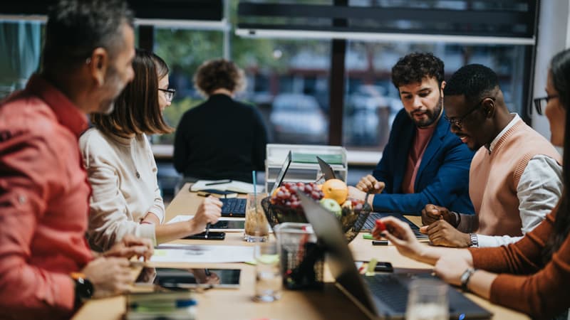 Group of people collaborating around a table, meant to symbolize strong partnership