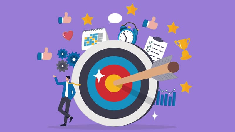 Illustration of a man leaning against a bullseye with other graphics like stars, graphs, a trophy, an alarm clock and thumbs up emojis surrounding it.