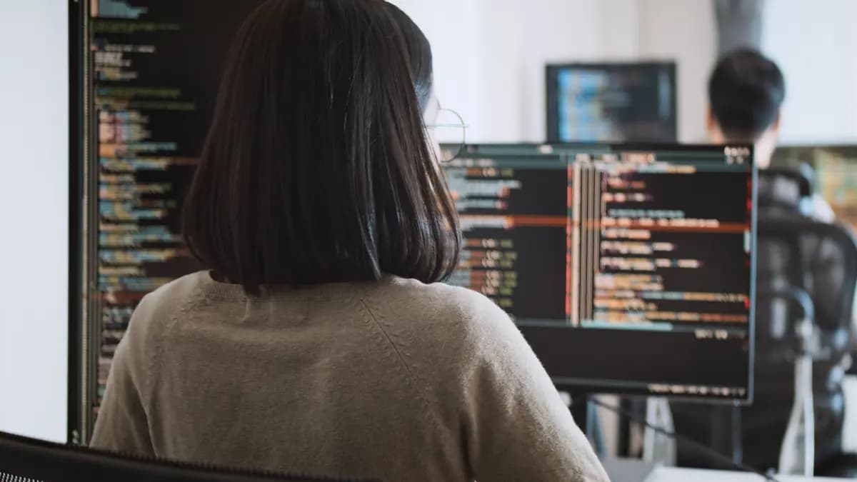 View from behind of a woman working at her monitor.