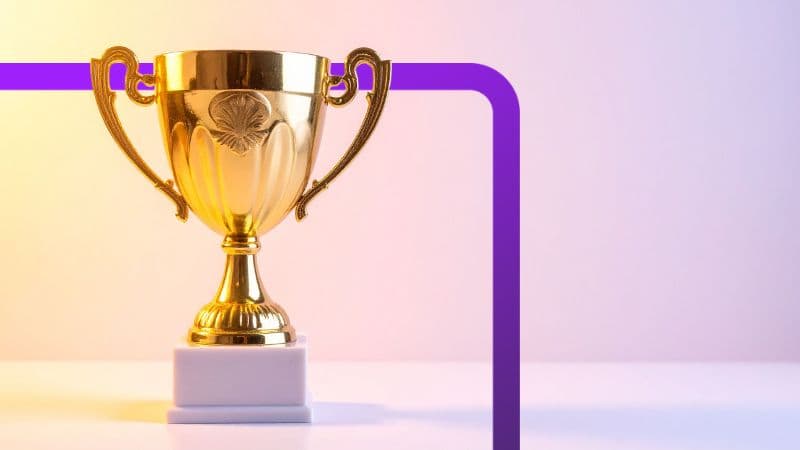A photo of a gold trophy on a white table.