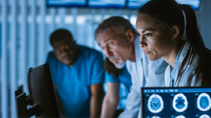 Three people looking at a monitor