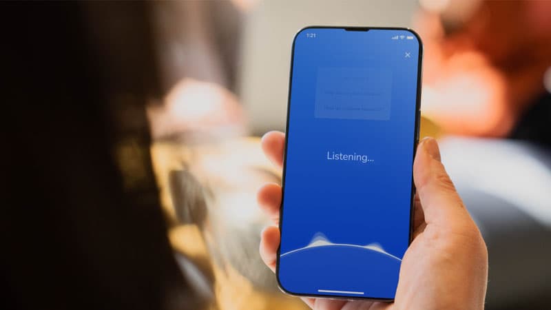 hand holding phone that says listening showing voice technology